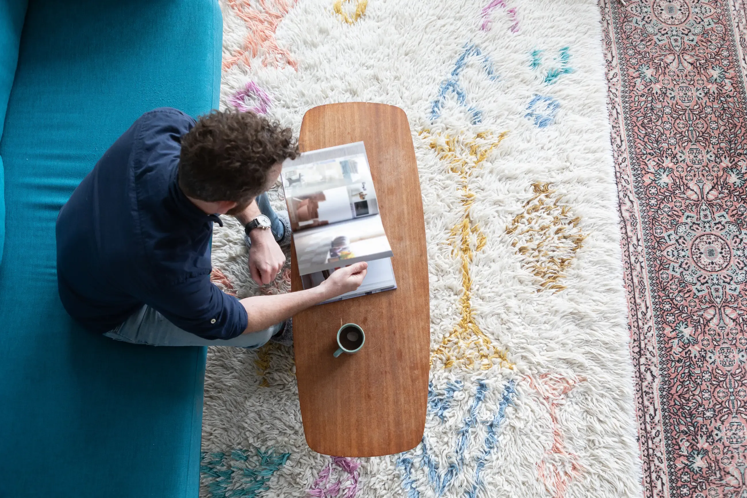 A man sitting on a couch reading a book 