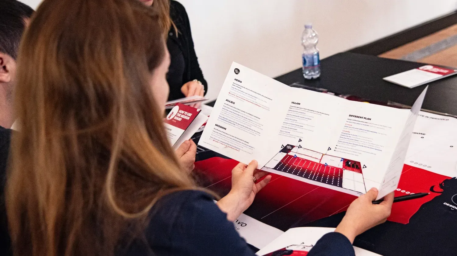 A woman looking at a brochure in her hands.