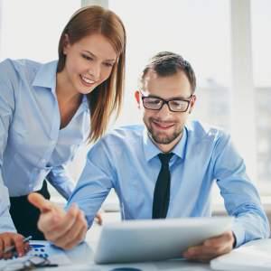 Two corporate managers looking at a laptop together