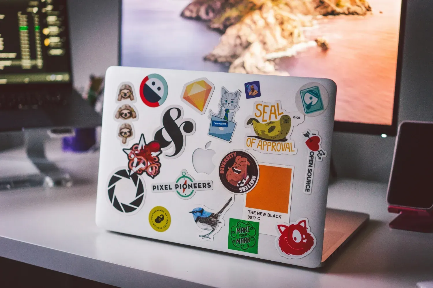 A laptop with various stickers on the shell.