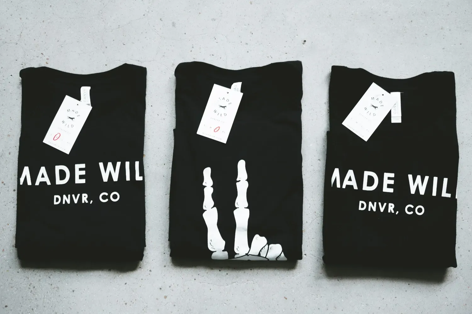 3 t-shirts folded with price tags on them.