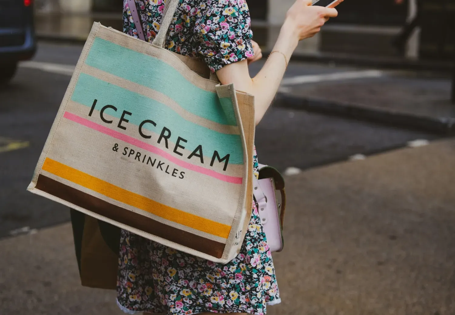 A close up of a woman carrying a tote bag that says