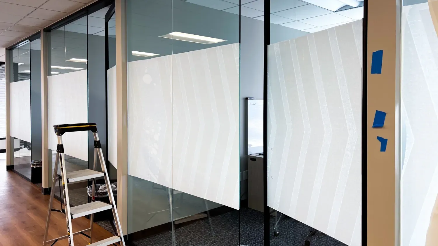 An image of custom window graphics being installed in an office.