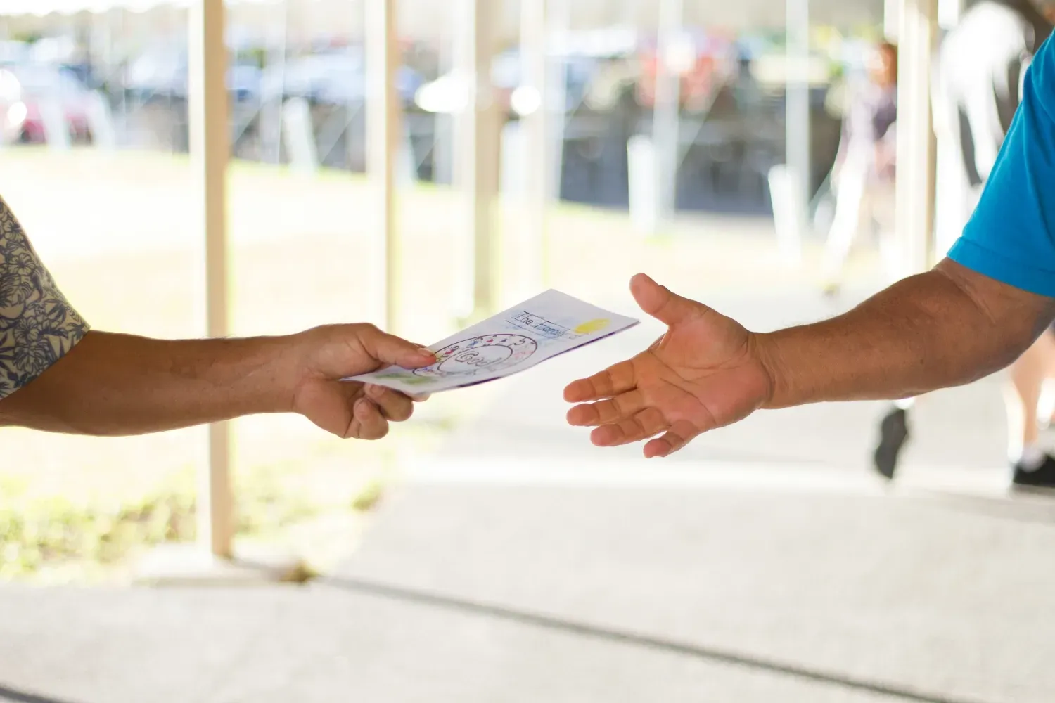 Someone handing another person a brochure.