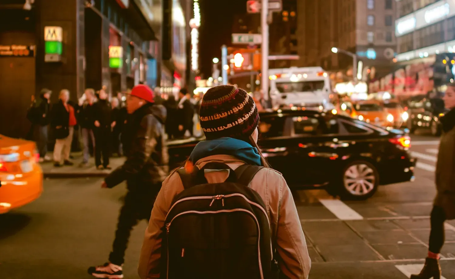A person in a large city looking around at an intersection.