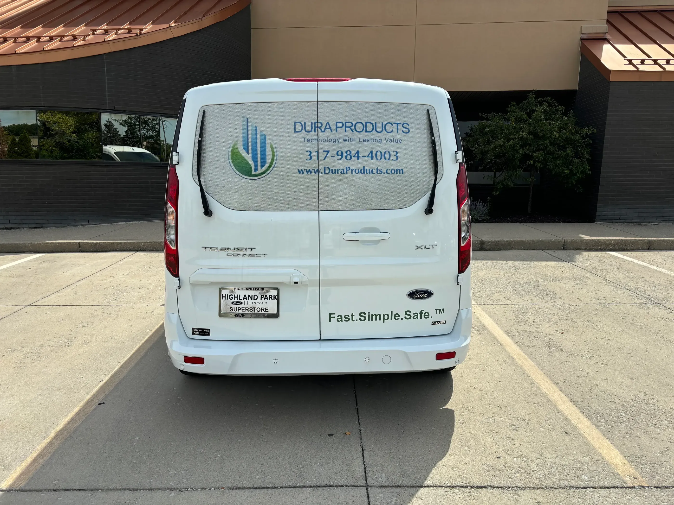 The rear view of a white van featuring the Dura Products logo and contact information, including a phone number and website. The tagline “Fast. Simple. Safe.” is also visible on the lower part of the rear door.
