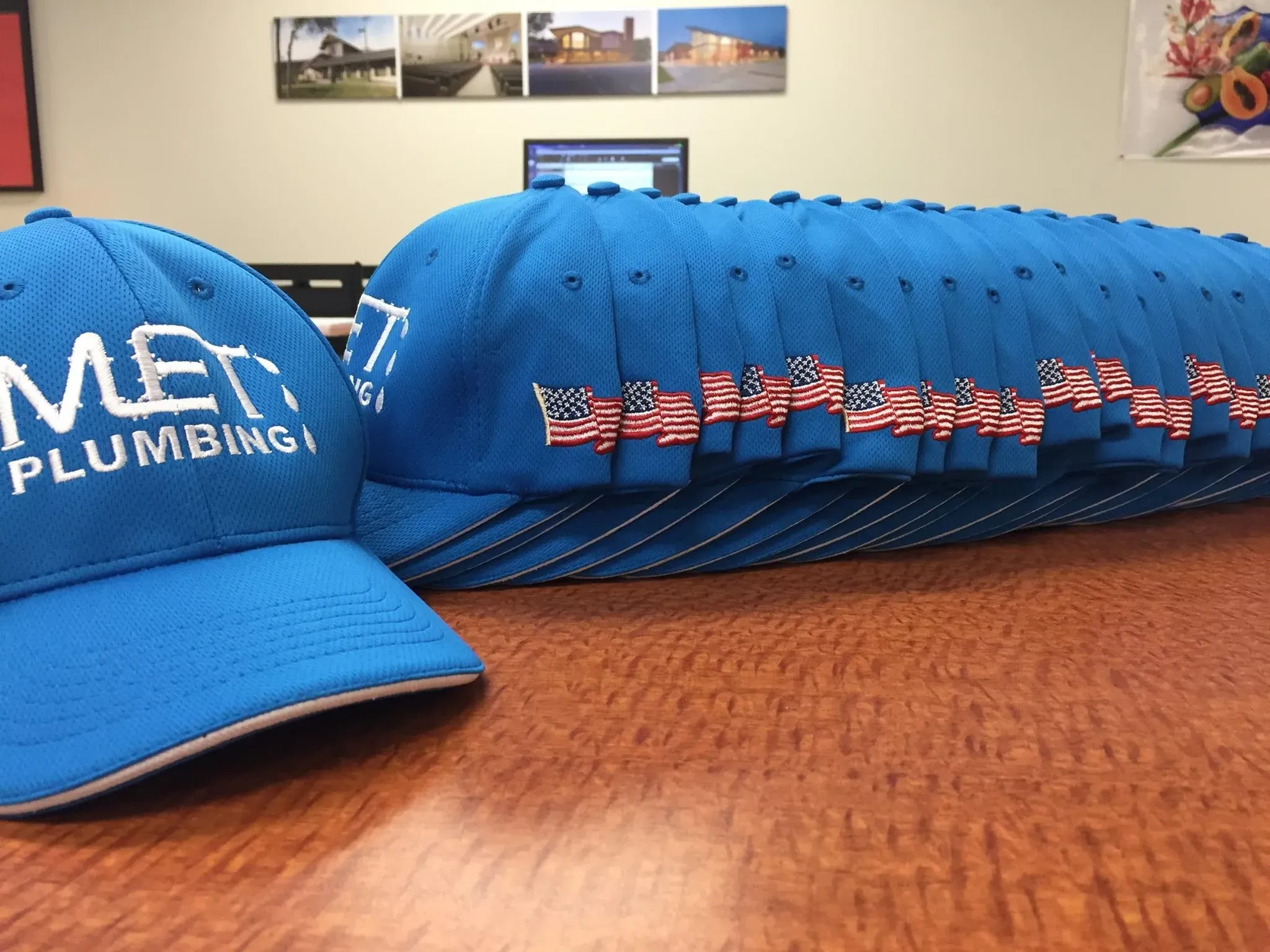 Blue embroidered caps with a company logo and flag