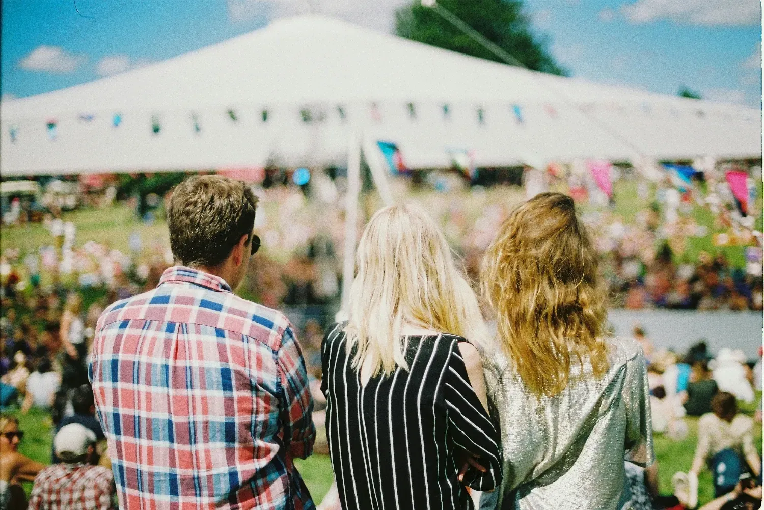 3 people outside looking at a community event.
