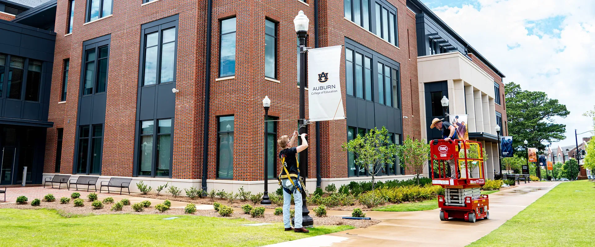 AlphaGraphics Hoover crew installing custom light pole banners at Auburn University's College of Education