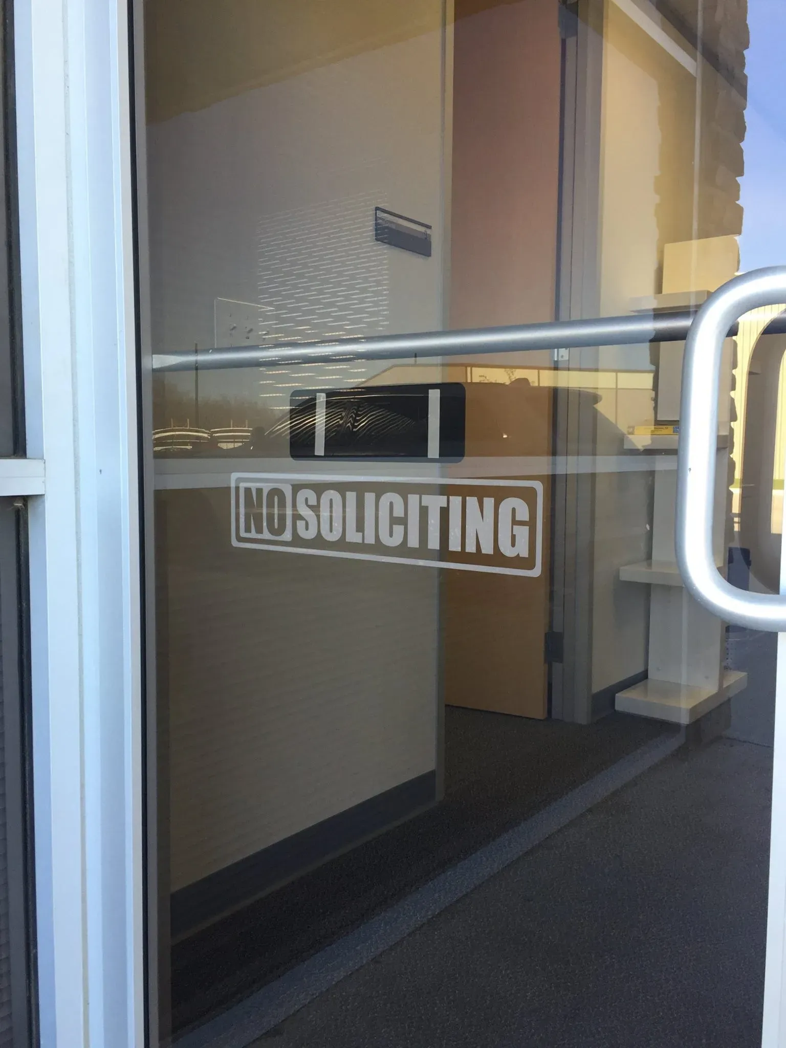 Frosted vinyl No Soliciting sign on a glass door