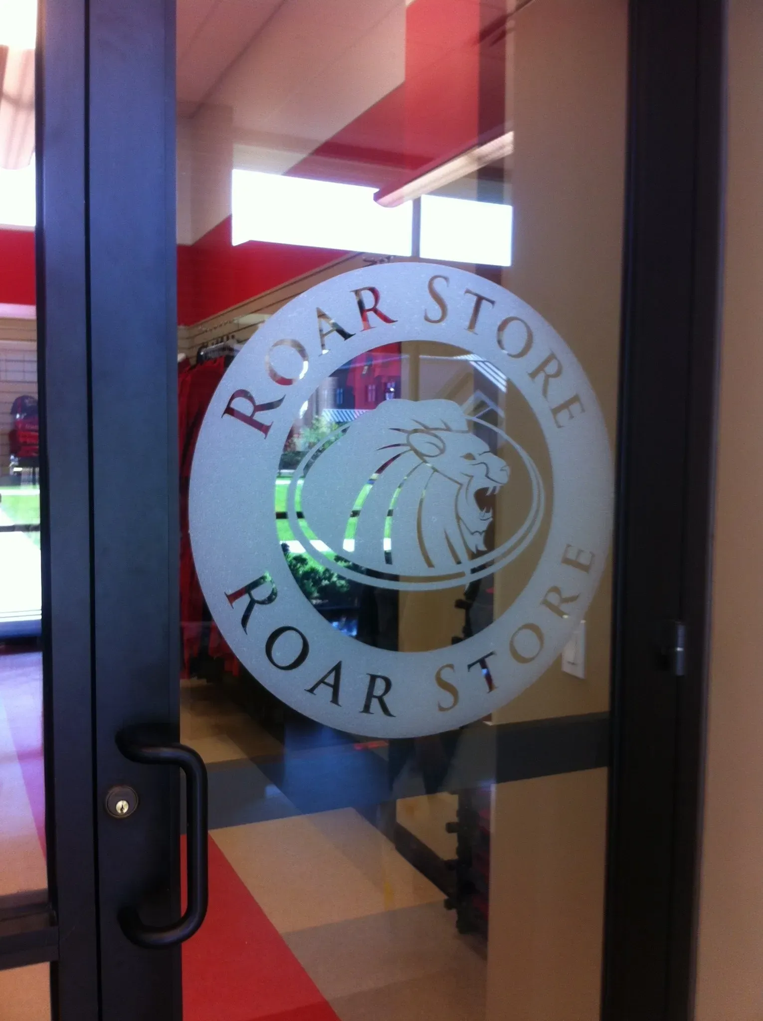 Frosted vinyl Roar Store logo on a glass door
