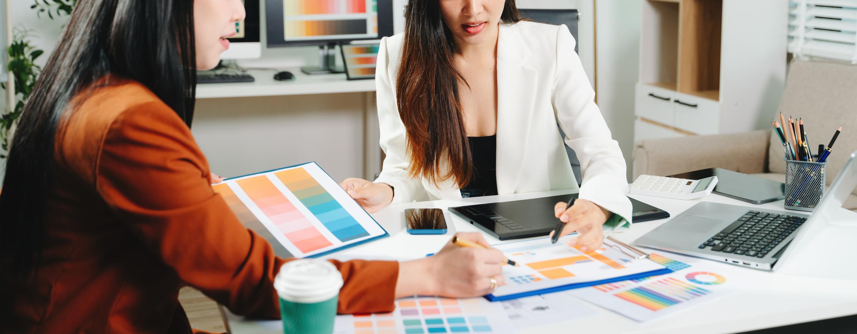 two women working together at a desk