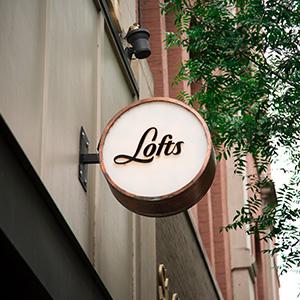 A vintage-looking business sign on the outside of a building