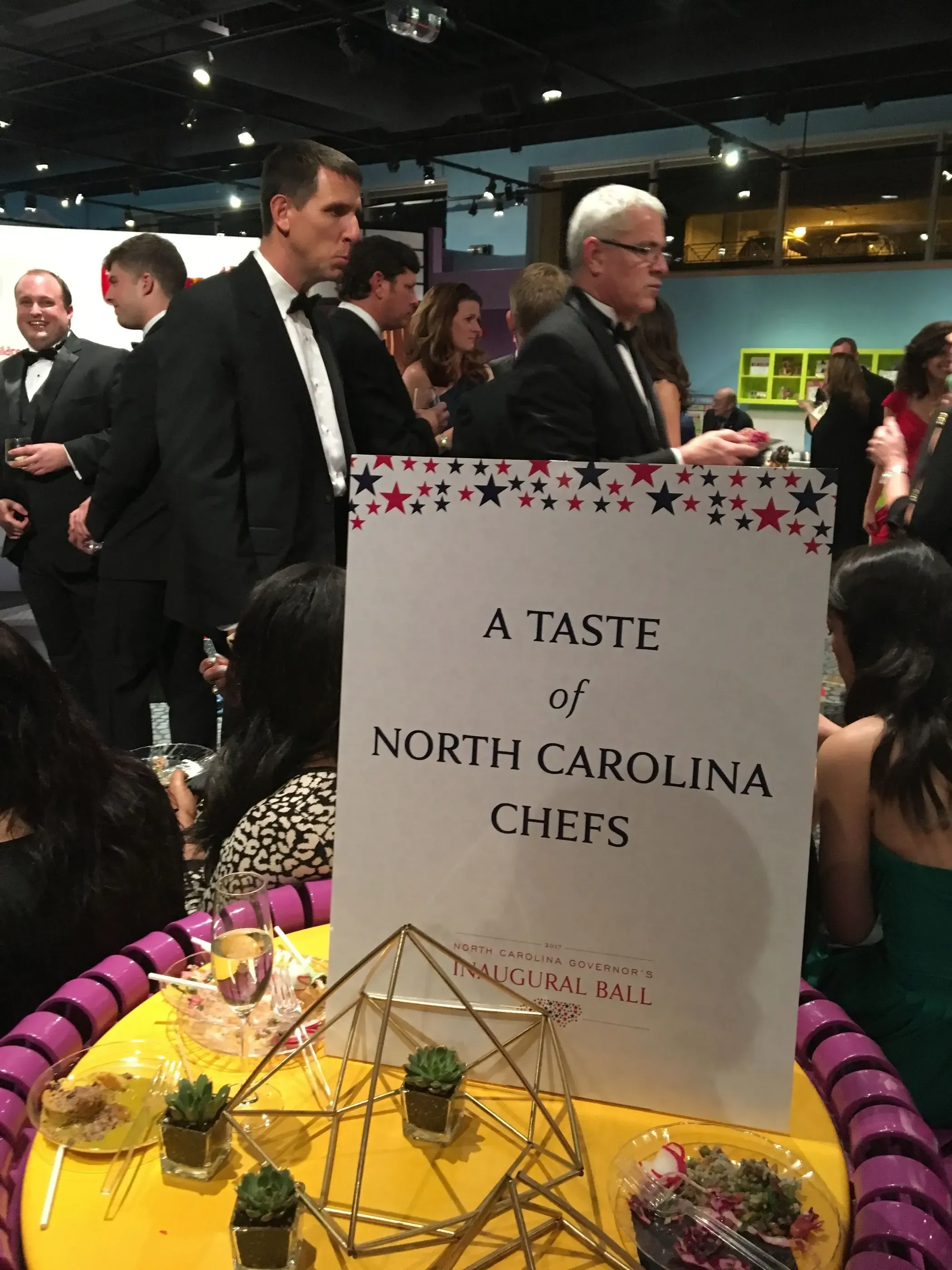 Table sign reading A Taste of North Carolina Chefs at a gala