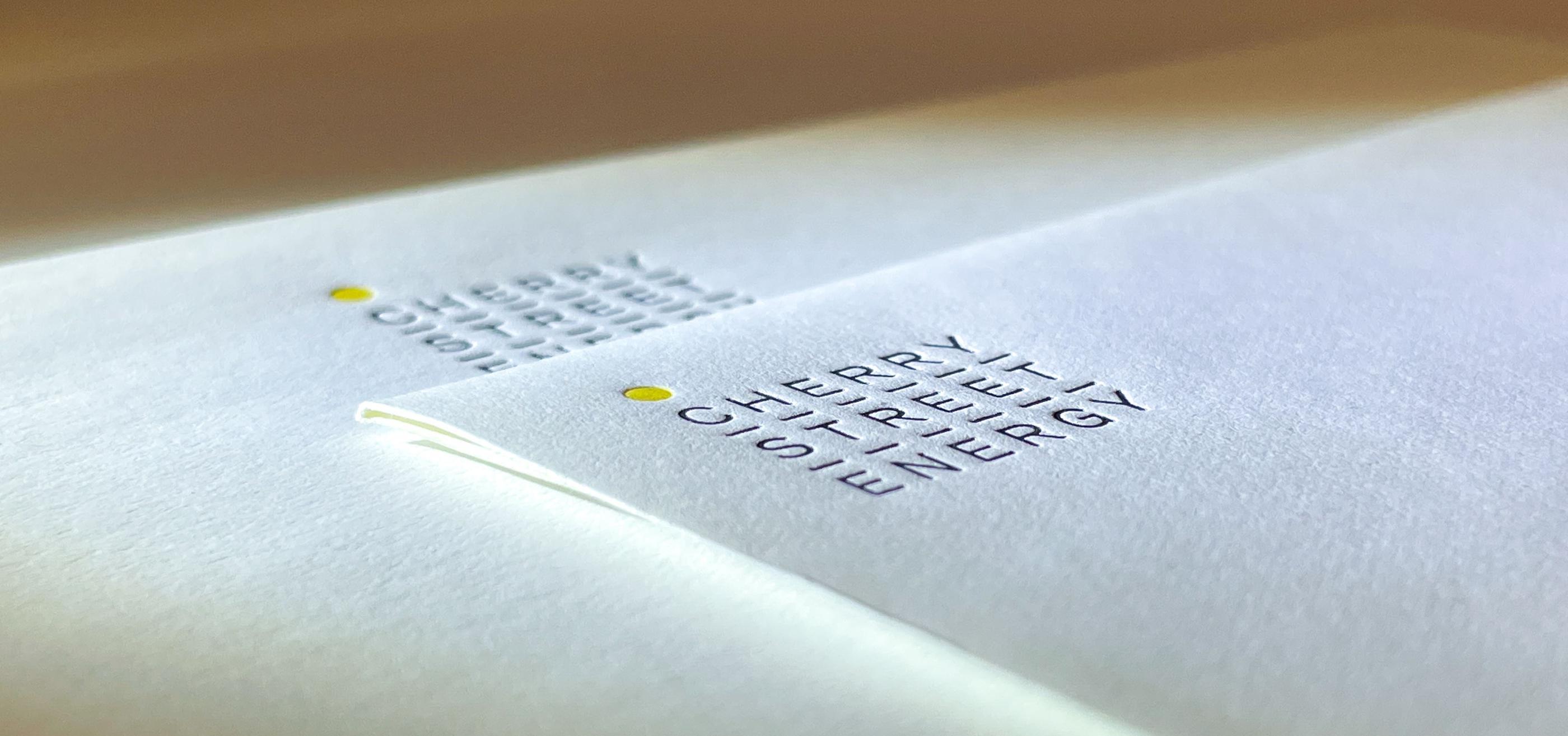 A close up of a letterhead and envelope with a very fine lined letterpress design.