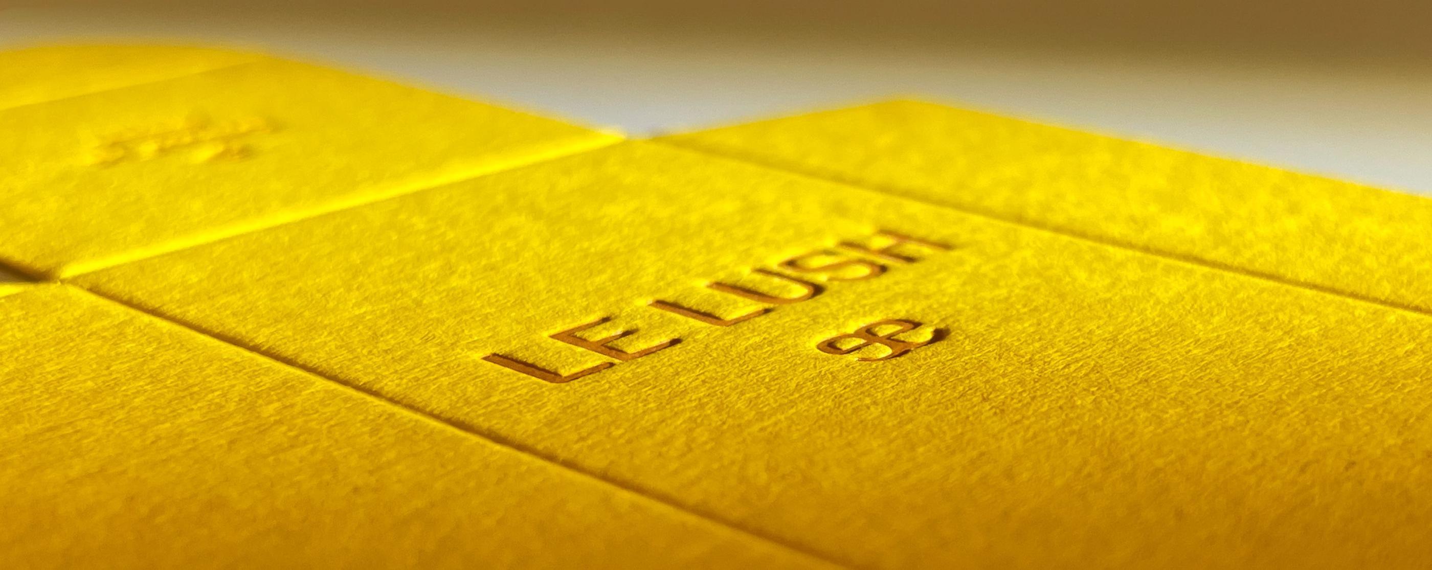 A close up of a yellow product package with a dark yellow letterpress design.