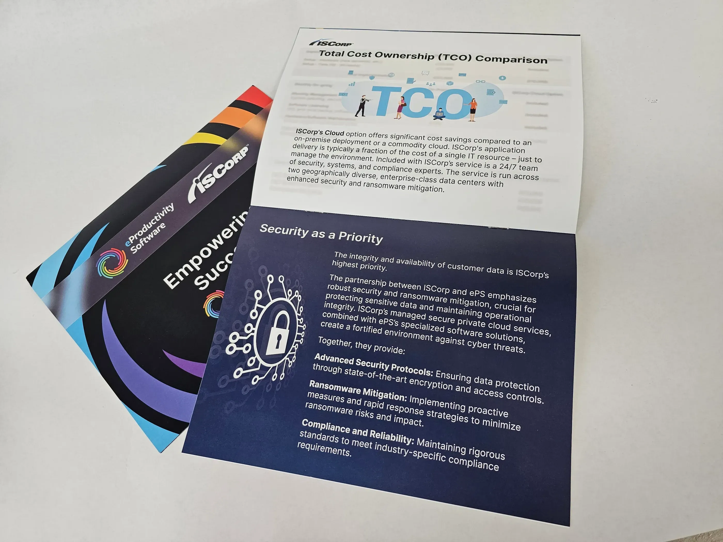 Printed marketing materials for ISCorp, including a booklet about cloud solutions and a flyer for ePS packaging services, designed for use at a global sales event.