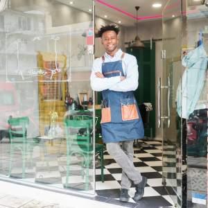 A barbershop owner standing in his store entrance