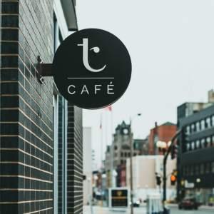 A nice cafe sign on a brick storefront wall