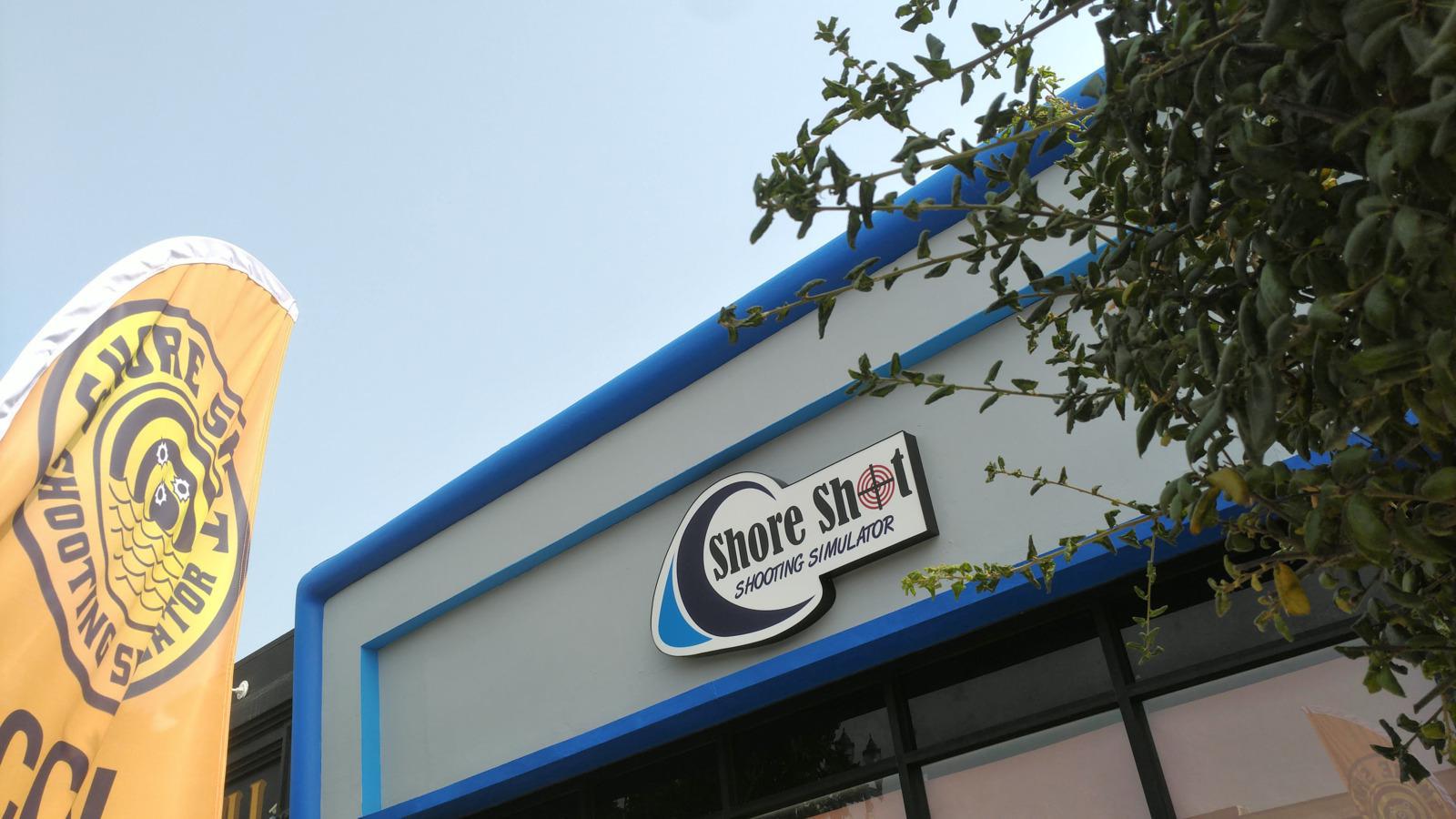 Small lightbox sign on building, illuminated, for Shore Shot