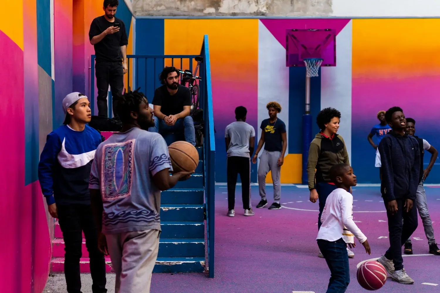 A group of people in a basketball court at an event with a custom floor and siding.