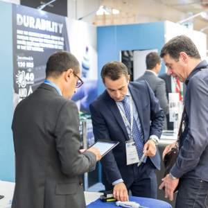 A group of businessmen talking at a trade show booth