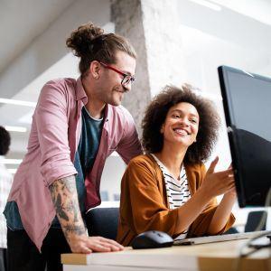 Two designers at a desk looking at a computer