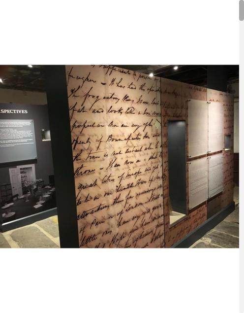 Large handwritten-script wall graphic in a museum exhibit