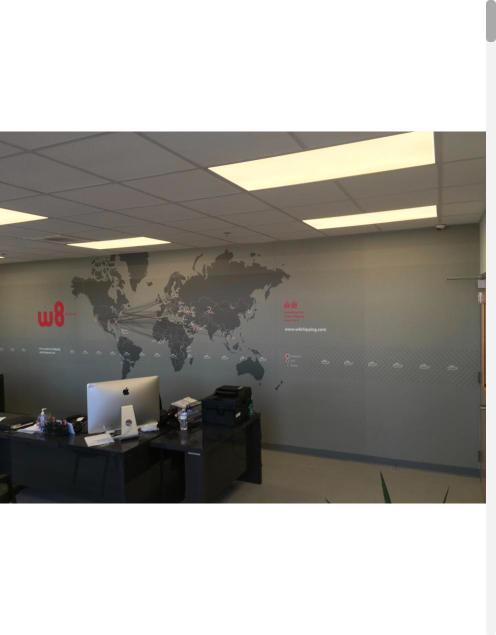 World map wall mural behind office desks
