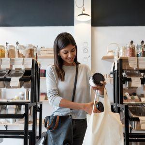 A woman shopping while carrying a reusable bag