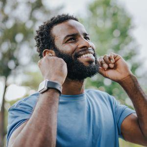 A happy man putting in earbuds
