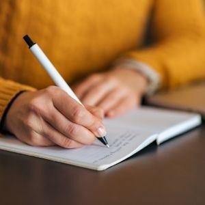 A person writing in a notebook