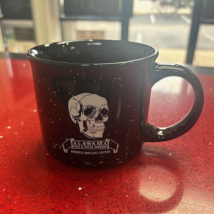 Black speckled camp mug with a custom dental practice logo
