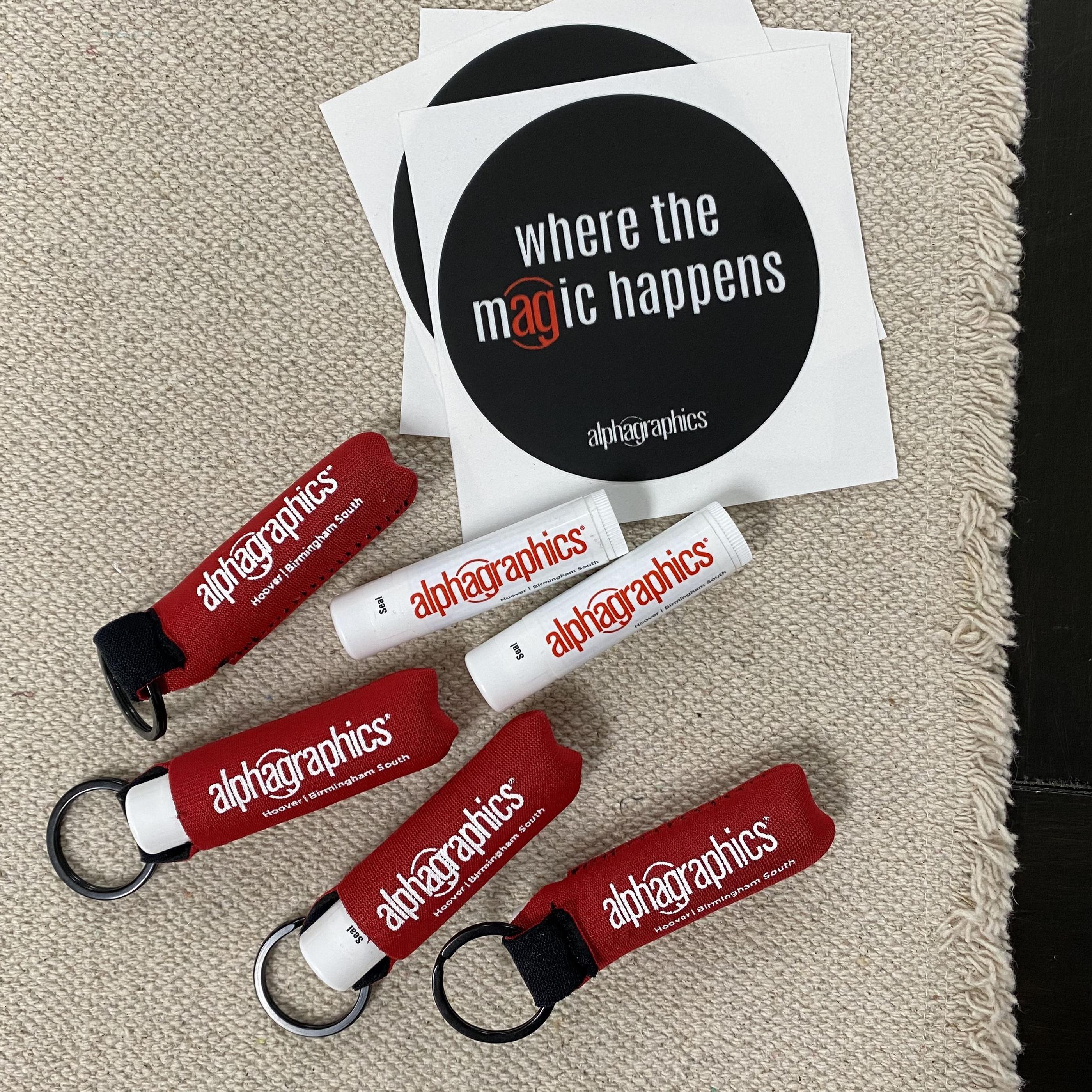 AlphaGraphics branded lip balm, keychain straps and stickers