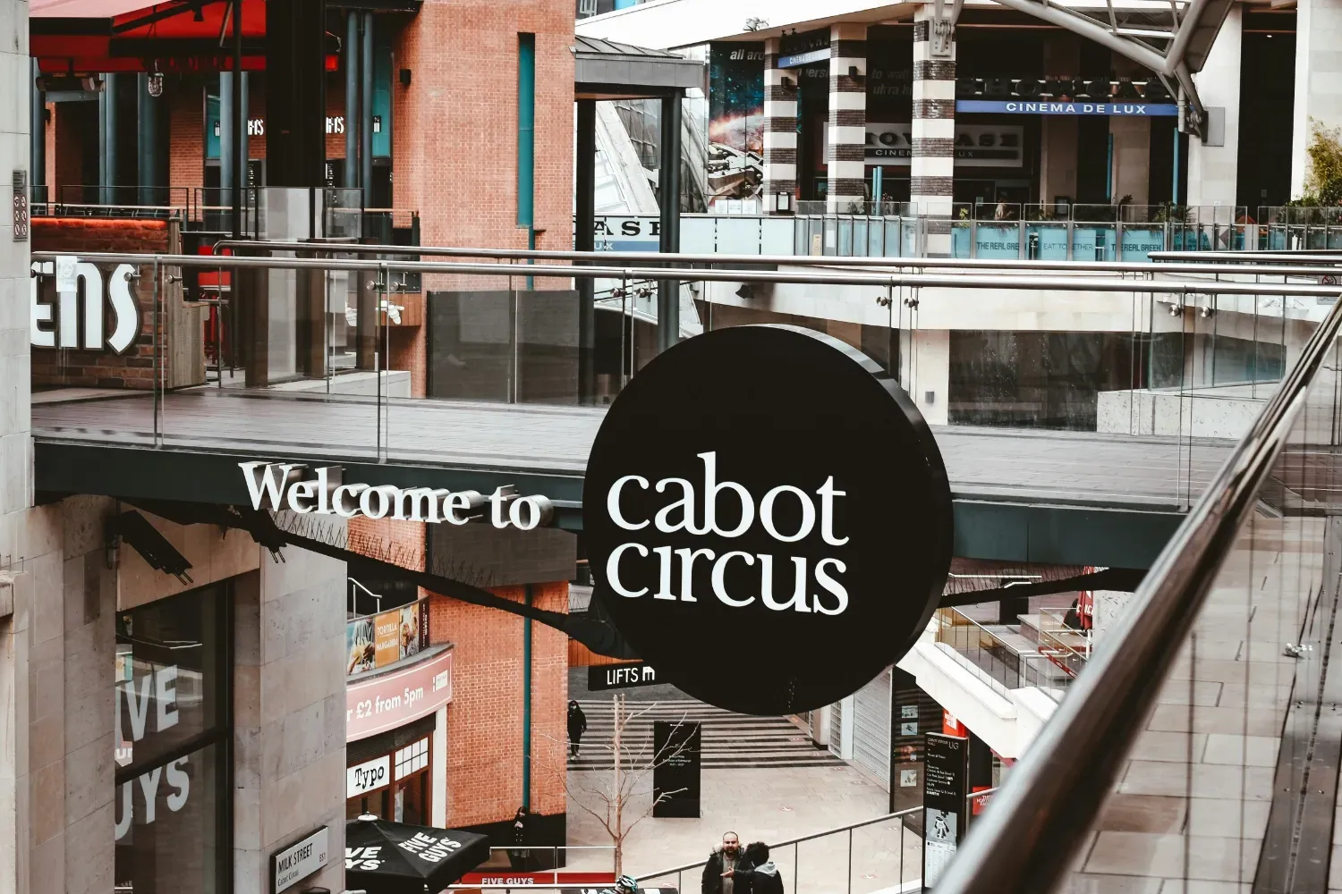 A sign for a business in a large courtyard area.