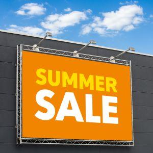 A bright orange and yellow Sales banner on a building
