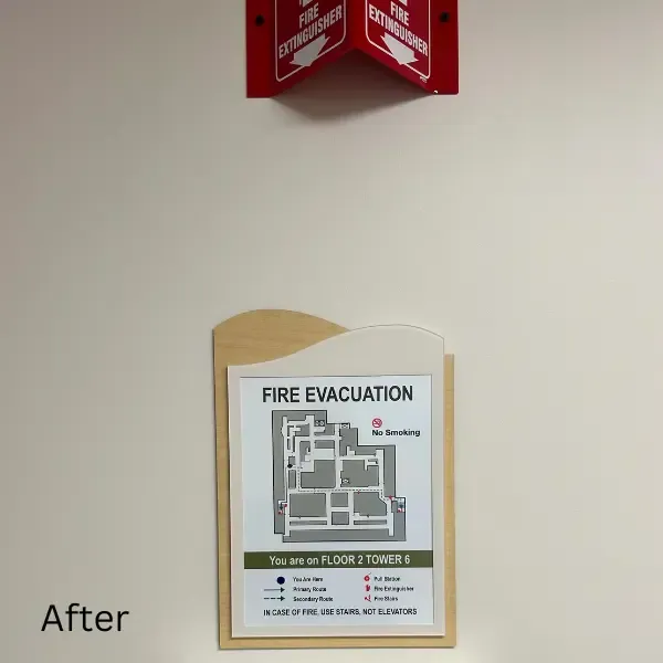 After image of a fire evacuation sign at Sunrise Hospital. The updated sign features a wooden frame with a curved top and a clearer layout of the floor plan, highlighting evacuation routes and fire safety instructions for the second floor.