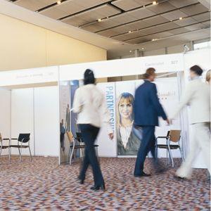 People walking by a tradeshow booth with large images
