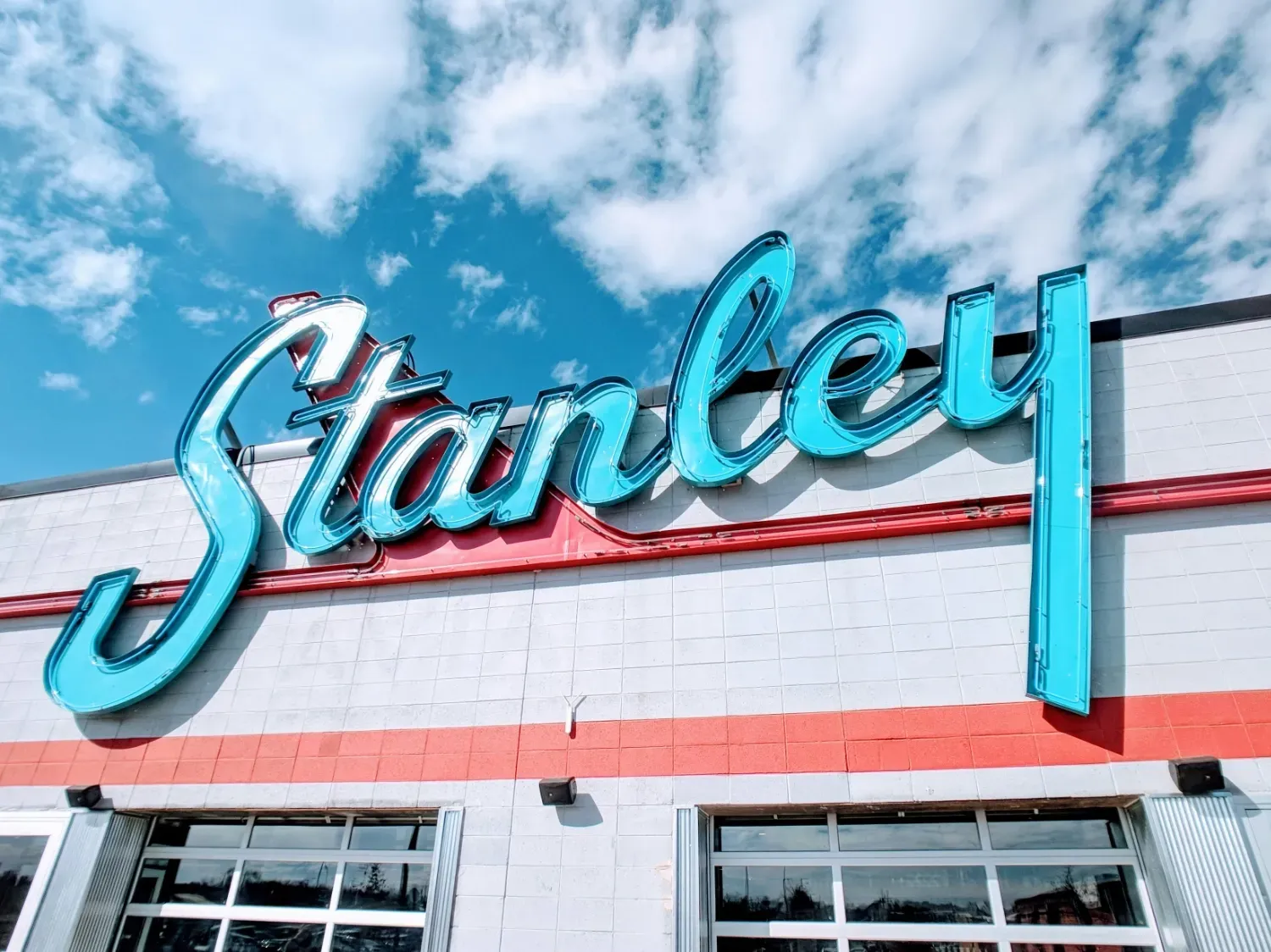 A photo of a large 80's-inspired neon sign on a building.