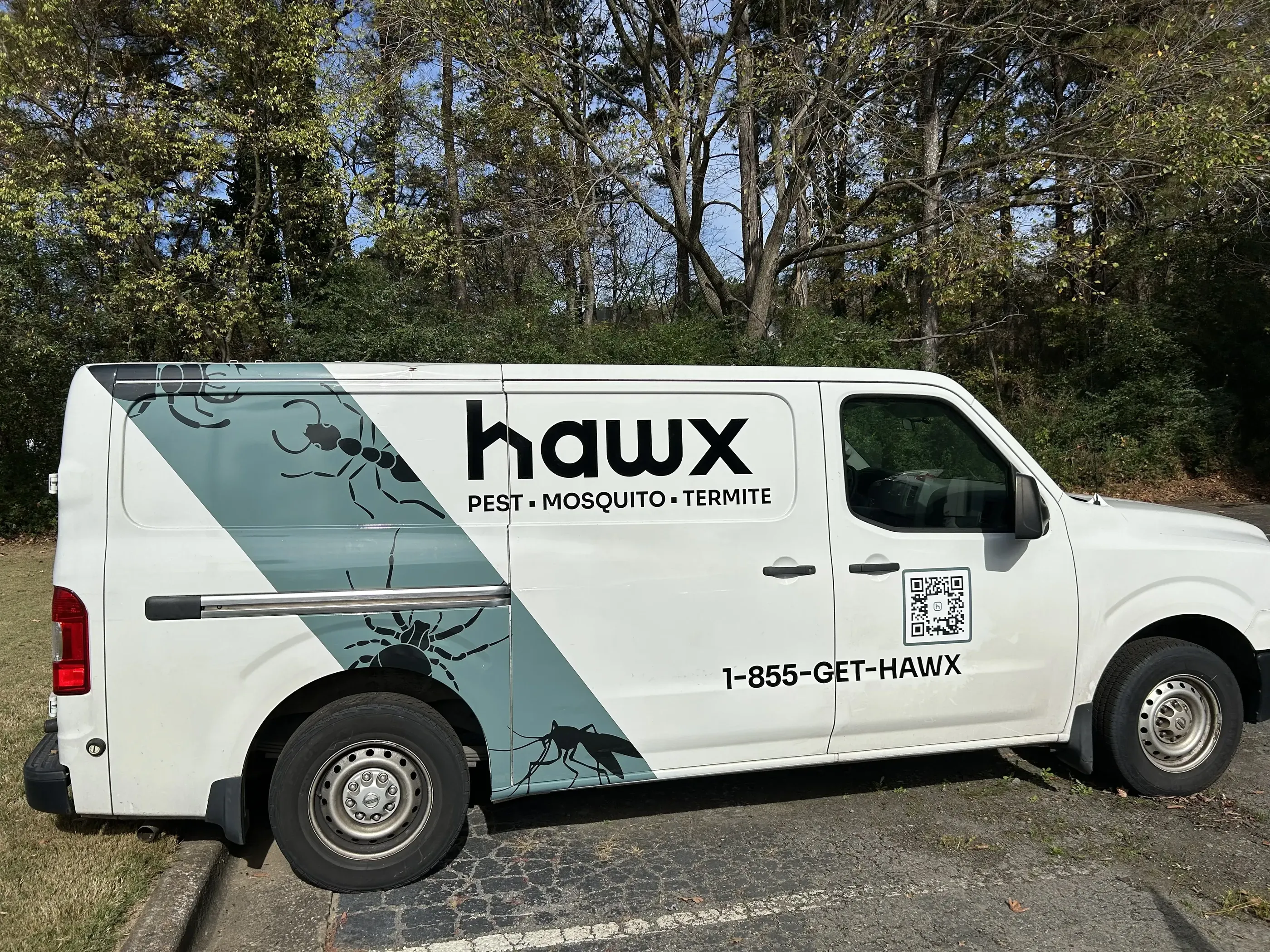 White Hawx Pest Control van with logo, insect graphic, and QR code.