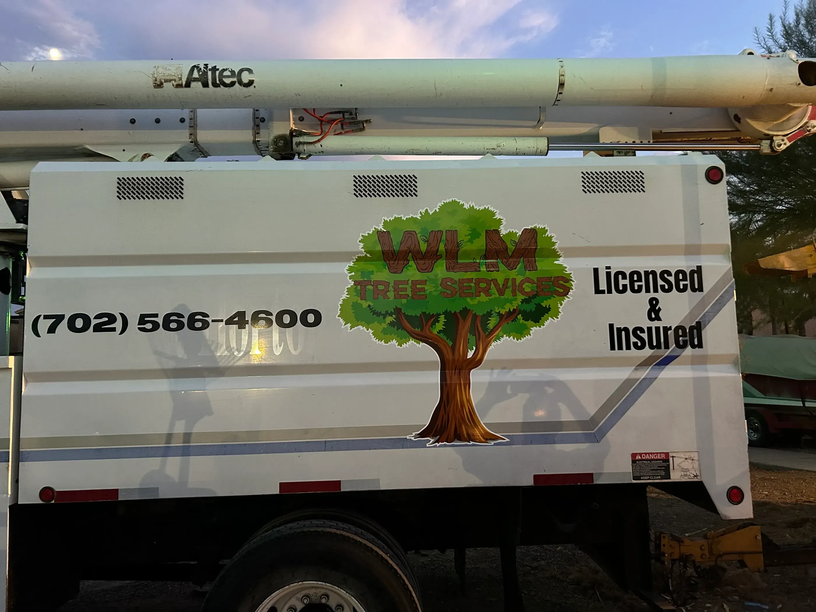 WLM Tree Services truck with tree logo and contact info.