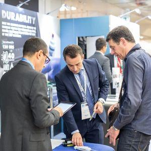 Three businessmen at a trade show booth