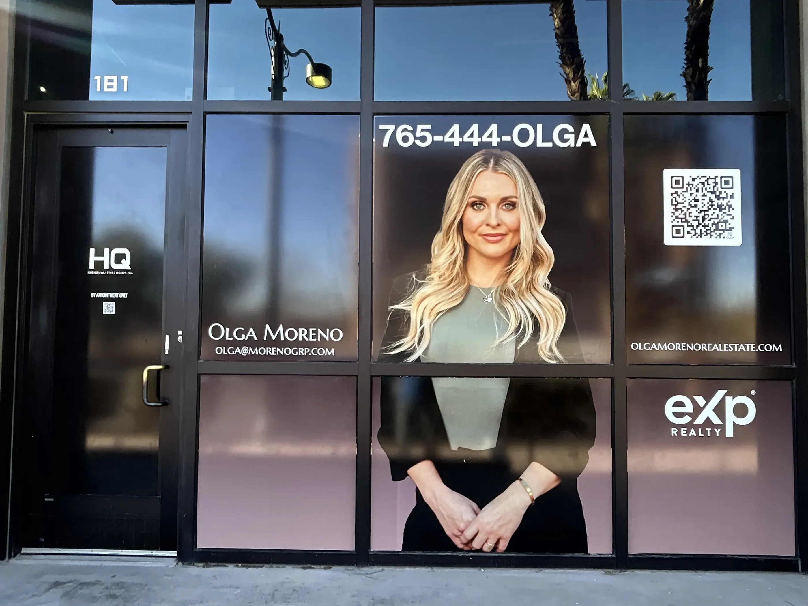 Storefront window graphics featuring real estate agent Olga Moreno and her contact information.